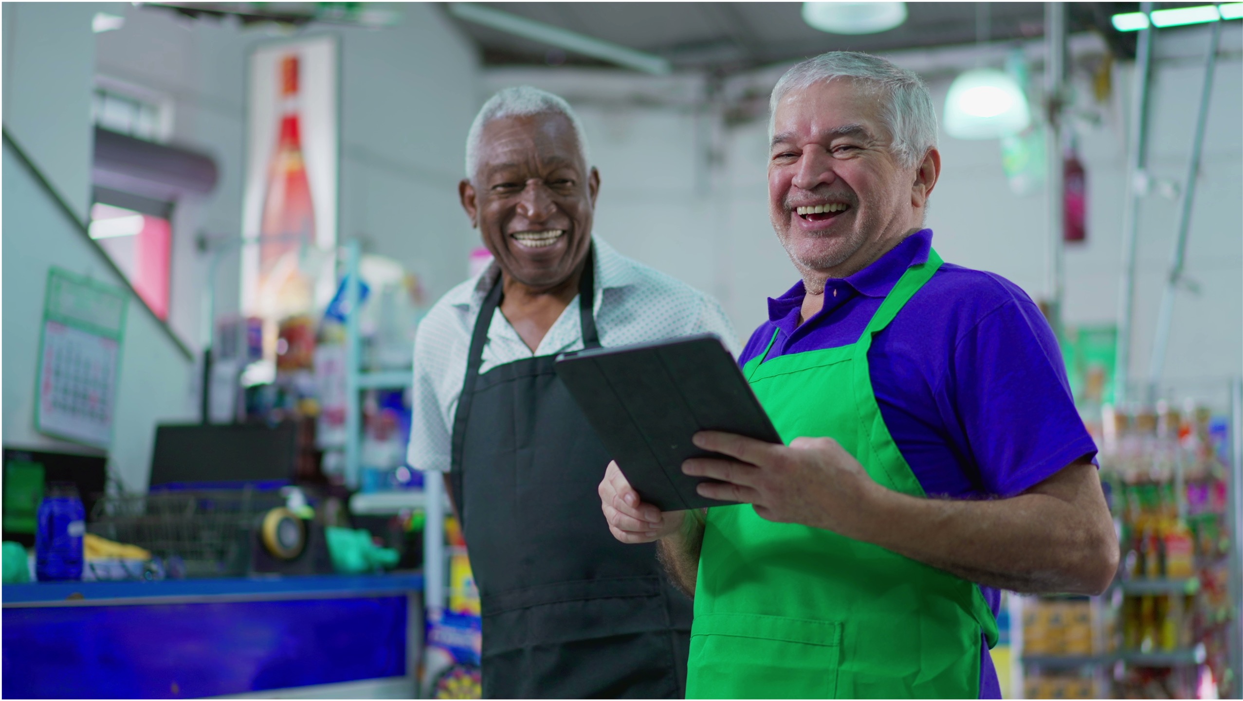 Two older gentleman smiling while at work